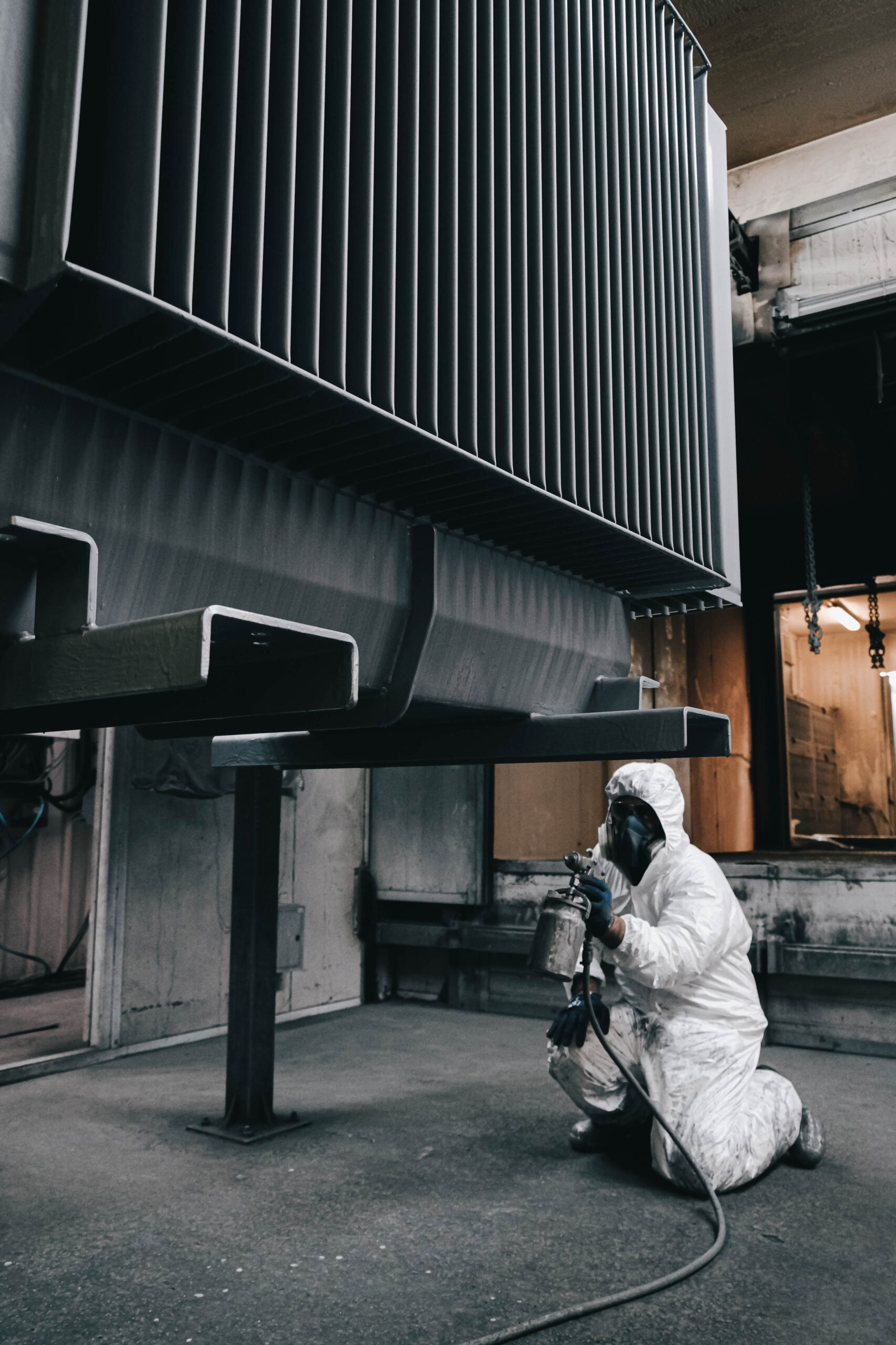factory-staff-wear-chemical-protective-clothing-work-paint-spraying Excavator bucket dropping dirt into an open trench.