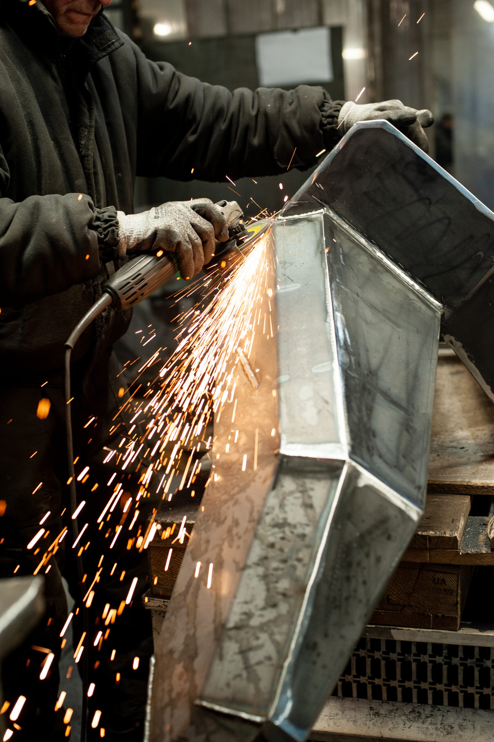 Excavator bucket dropping dirt into an open trench.